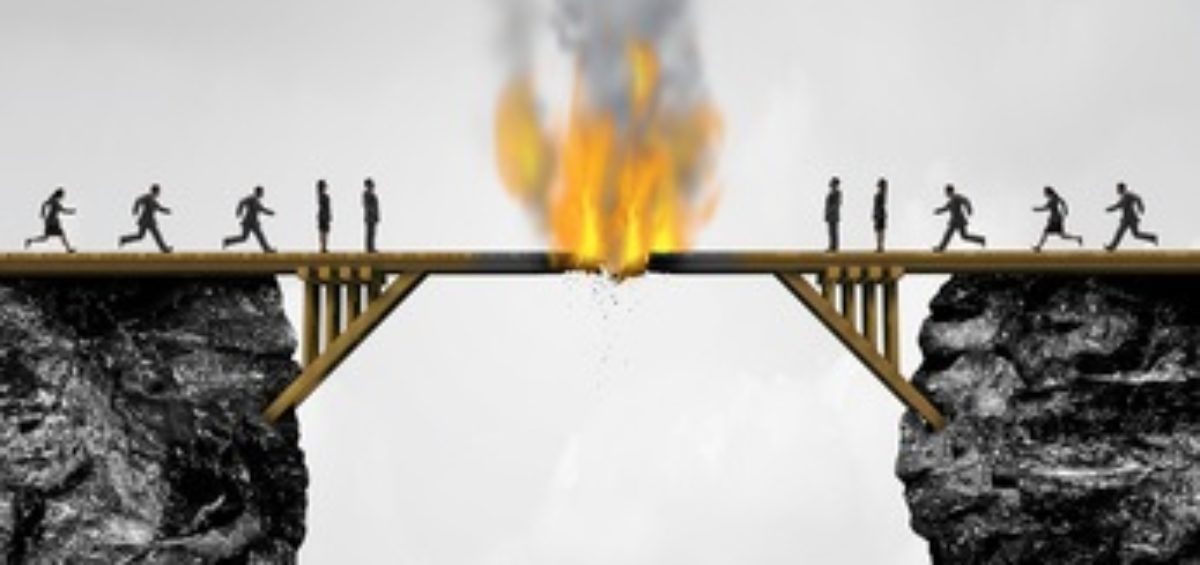 Burning bridge concept as groups of people divided by a wooden bridge on fire as a business connection risk metaphor for destroying a link or isolationism with 3D illustration elements.