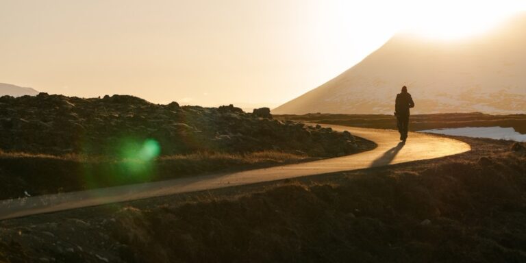 Person walking on a path through the hills