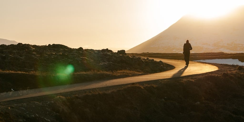 Person walking on a path through the hills