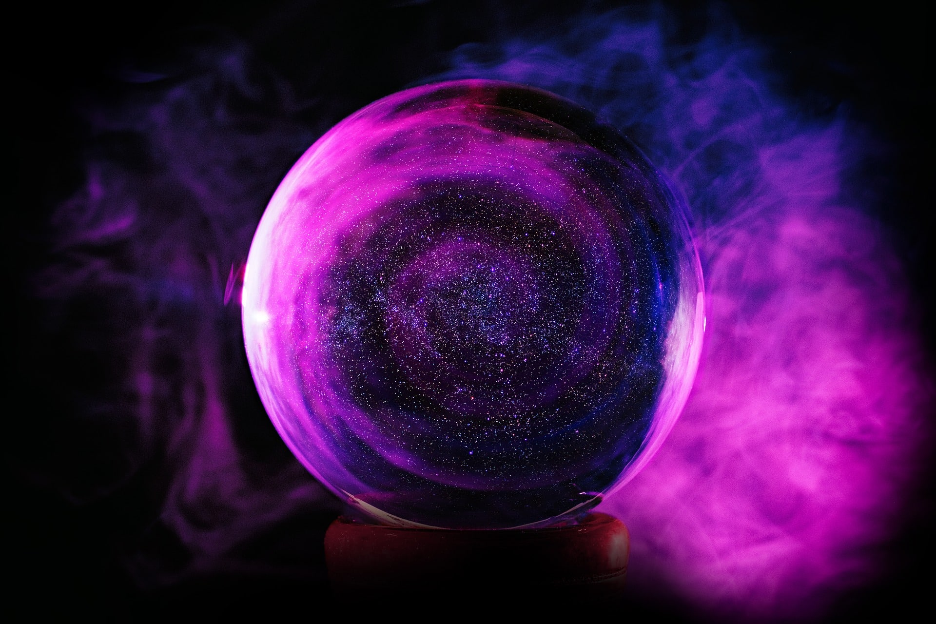 A crystal ball surrounded by purple smoke