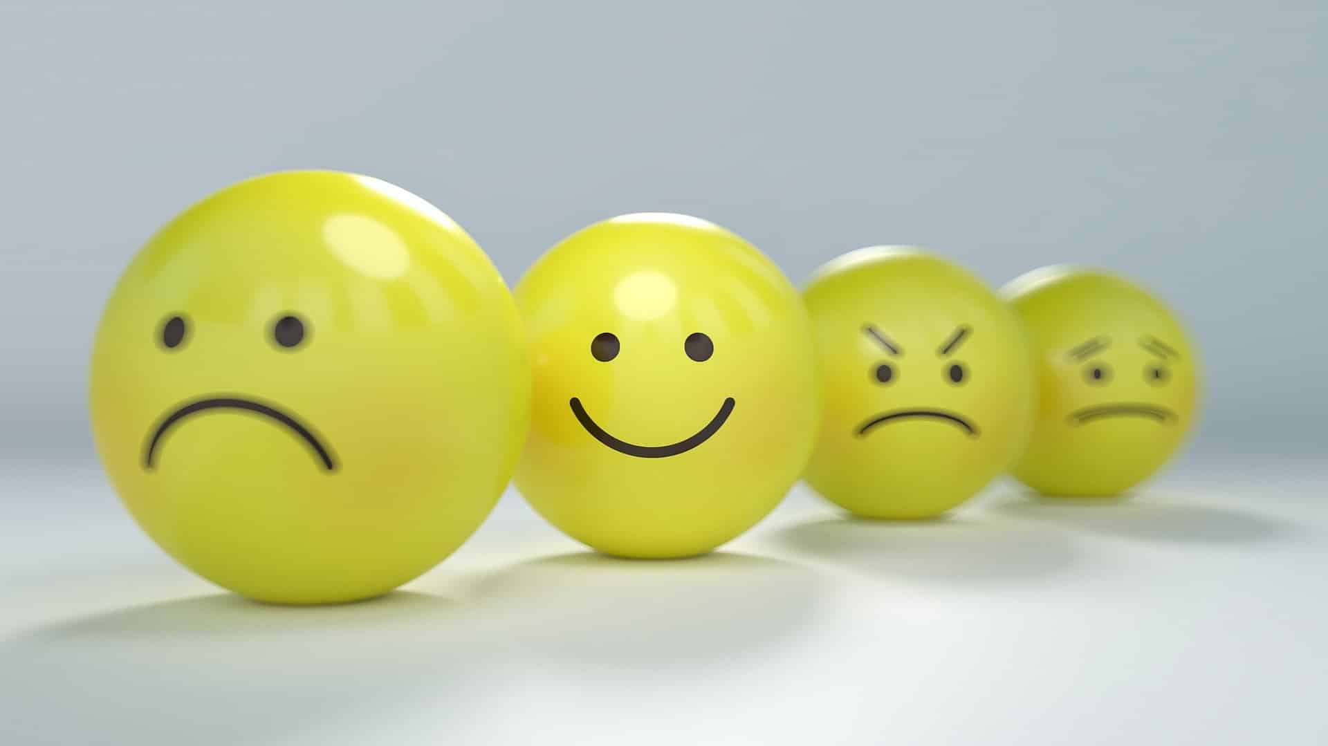 Four balls. three with sad faces, one with a smile