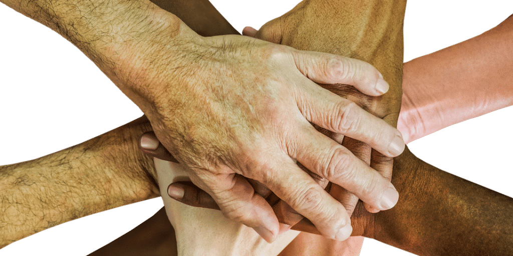 Hands on top of one another in a huddle to signify a partnership