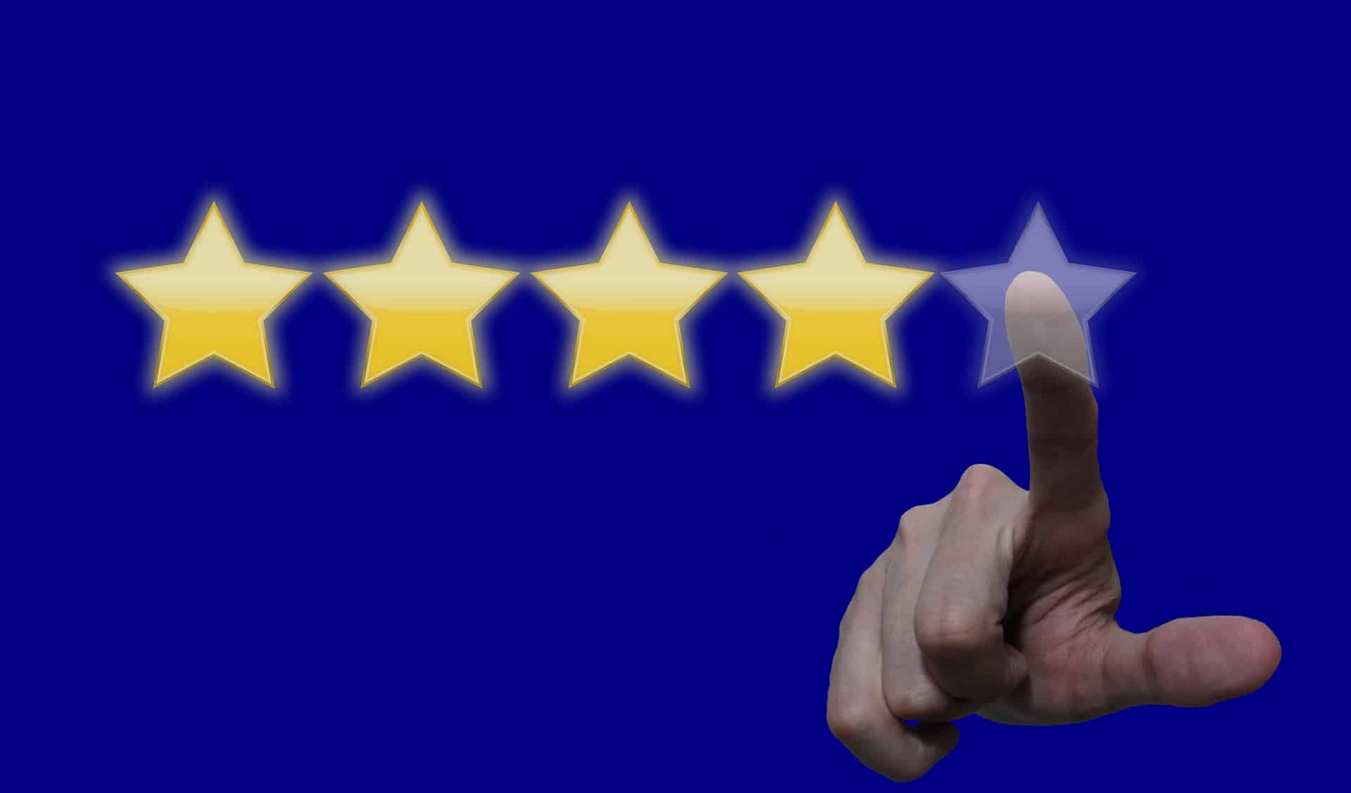 A hand reaching out to press a star in order to leave a 5 star review