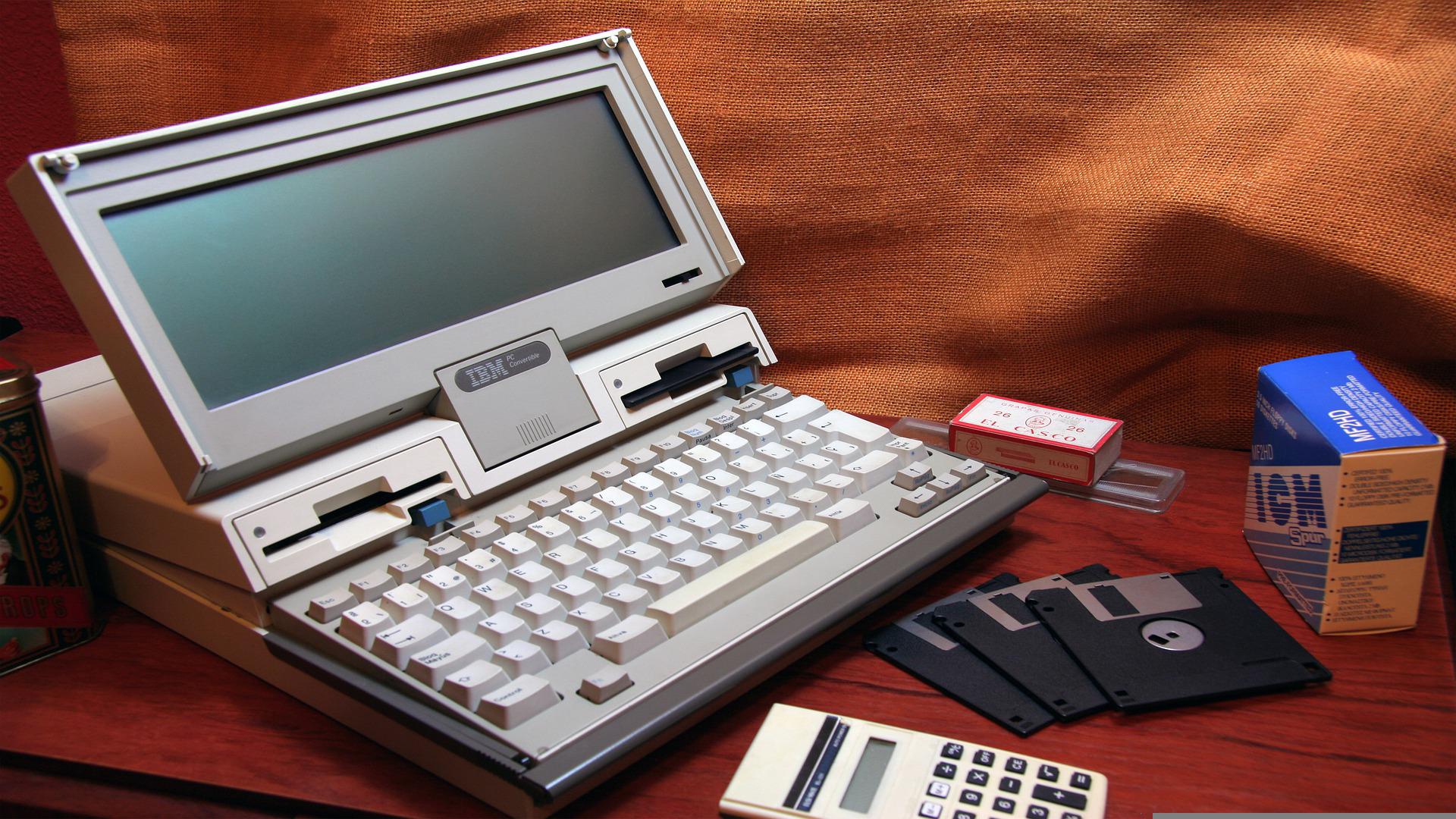 An image of an old IBM computer and floppy disks meant to represent legacy systems and old technology.