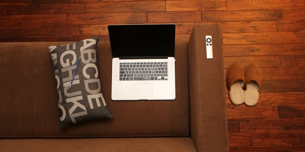 A picture of a laptop sitting on a couch meant to depict working from home